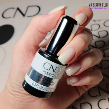Mujer que muestra en sus manos producto Plexigel de CND